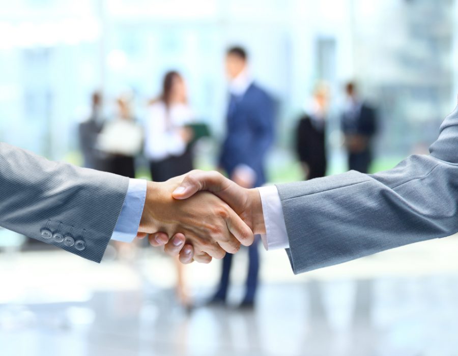 Two people wearing business suit shaking hands